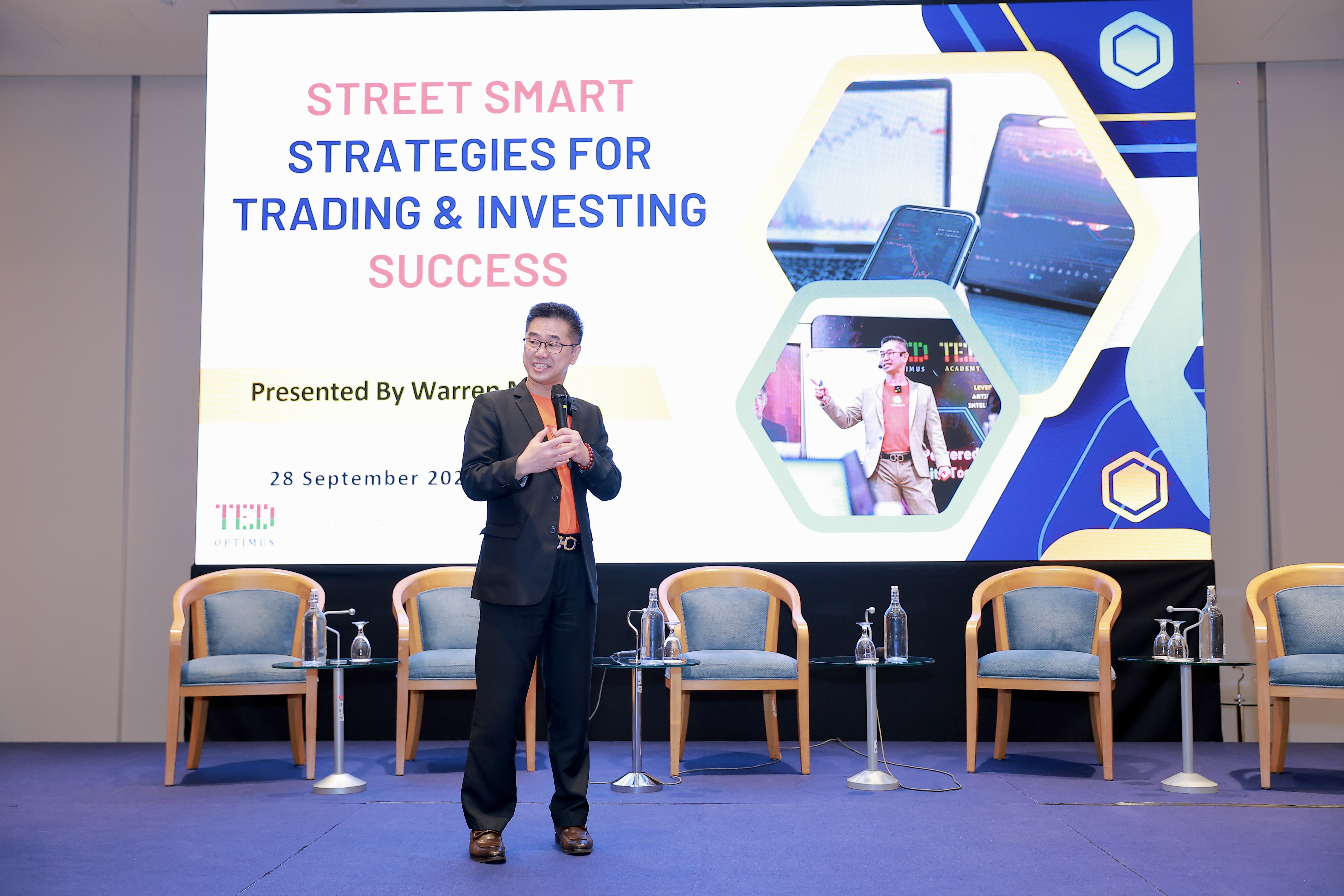 Warren Mak speaking on stage at a live trading seminar